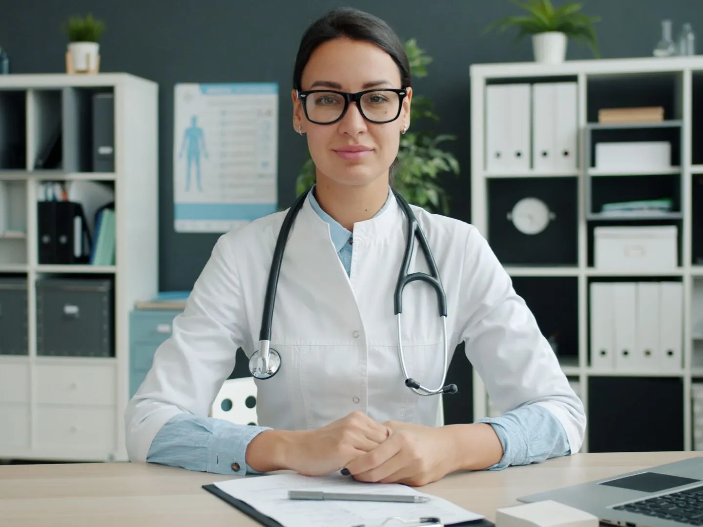 Doctor at her desk reviewing pre-certification documentation